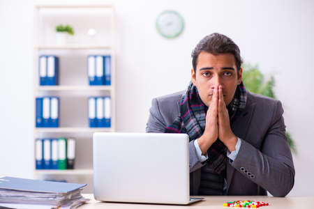 Young male employee suffering at workplaceの写真素材