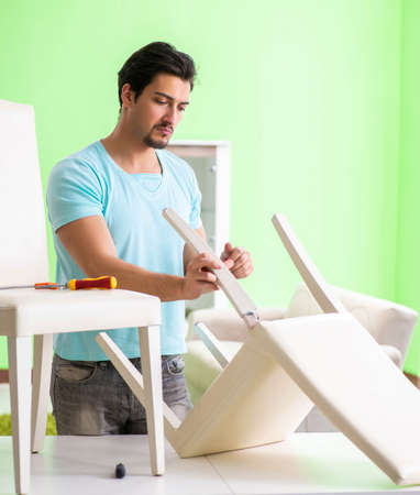Man repairing furniture at homeの写真素材
