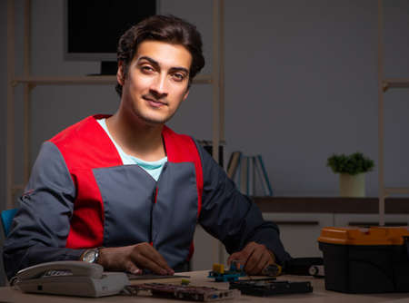 Young handsome repairman repairing computerの写真素材