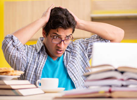 Student preparing for exam sitting at the kitchenの写真素材