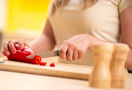 The young woman preparing salad at home in kitchenの写真素材