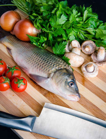 Uncooked fish on cutting board in meal preparation conceptの写真素材