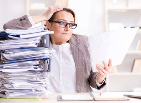 Businesswoman very busy with ongoing paperworkの写真素材