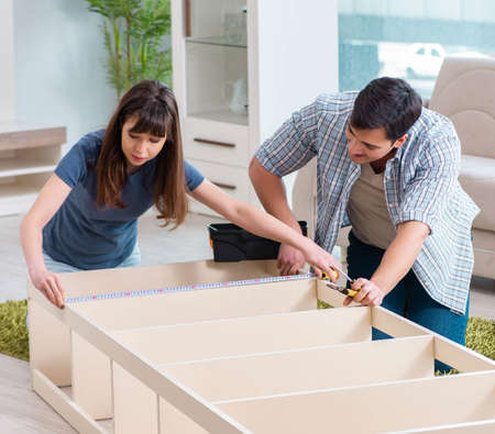 Young family assembling furniture at new houseの写真素材