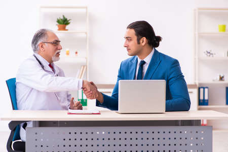 Young businessman meeting with old doctorの写真素材