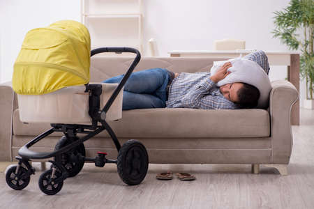 Young father looking after newborn baby at homeの写真素材