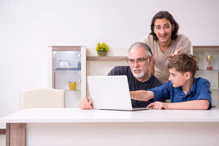 Grandfather learning new technology from son and grandson