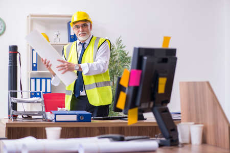 Old male architect working in the office
