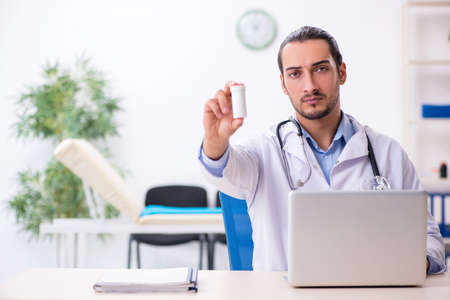 Young handsome male doctor working in the clinicの写真素材