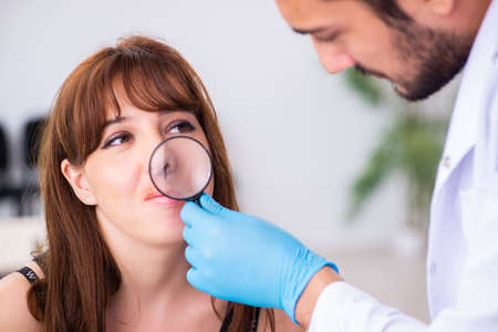 Young woman visiting male doctor dermatologist