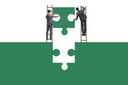 Businessman in teamwork concept with jigsaw puzzleの写真素材