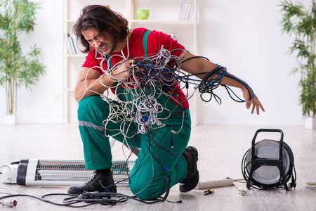 Funny young male electrician working indoorsの写真素材