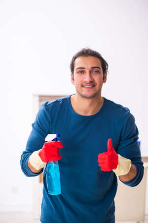 Young man husband doing housework at homeの写真素材