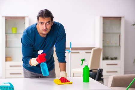 Young man husband doing housework at home