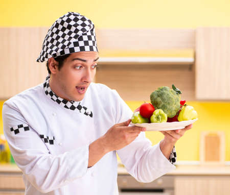 Young professional cook preparing salad at homeの写真素材