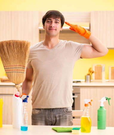 Single man cleaning kitchen at home