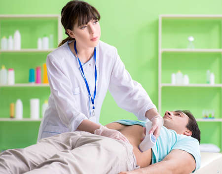 Young man visiting radiologyst for ultrasound procedureの写真素材