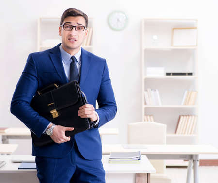 Young handsome businessman employee working in office at deskの写真素材