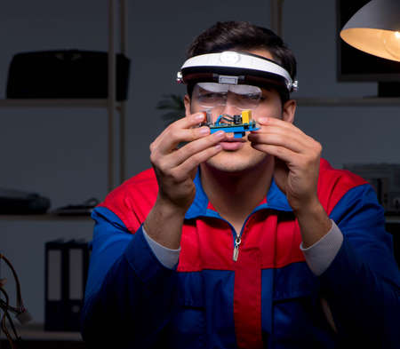 The computer specialist repairing pc late at night