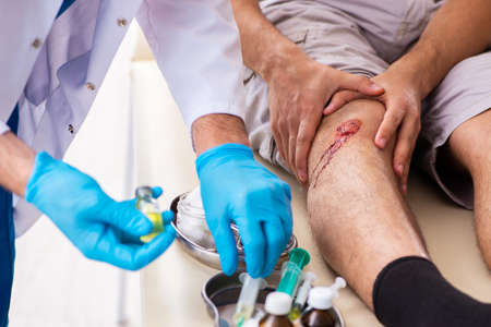 Leg injured man visiting old doctor in first aid concept