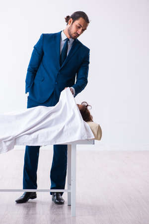 Police coroner examining dead body corpse in morgueの写真素材