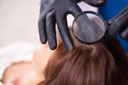 Young woman visiting beautician in hair transplantation conceptの写真素材