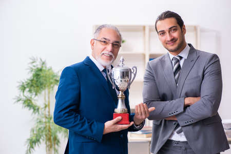 Two male employees working in the officeの写真素材