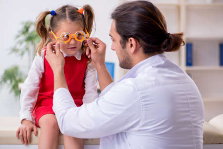 Small girl visiting young male doctor oculistの写真素材