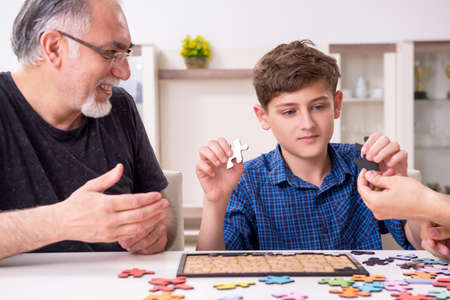 Three generations of family playing jigsaw puzzle game