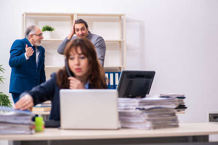 Two male and one female employees working in the officeの写真素材