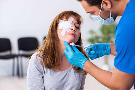 Young head injured woman visiting young male doctor