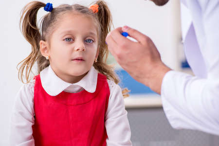 Small girl visiting young male doctor oculistの写真素材