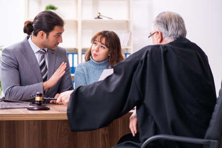 Young woman in courthouse with judge and lawyerの写真素材