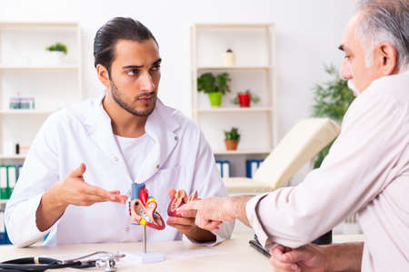 Old man visiting young male doctor cardiologist
