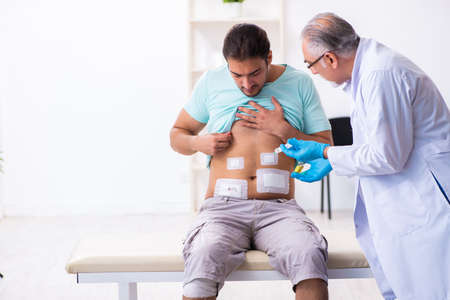 Injured young man visiting experienced male doctor