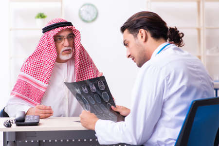 Old male arab visiting young male doctorの写真素材