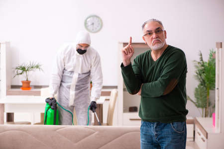 Young male sanitizer and old man indoorsの写真素材