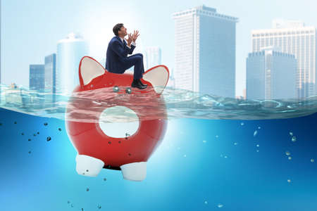 Businessman in debt concept with piggybankの写真素材