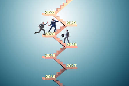 Businessman climbing stairs on yearly basisの写真素材