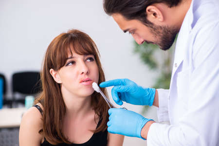 Young woman visiting male doctor dermatologistの写真素材