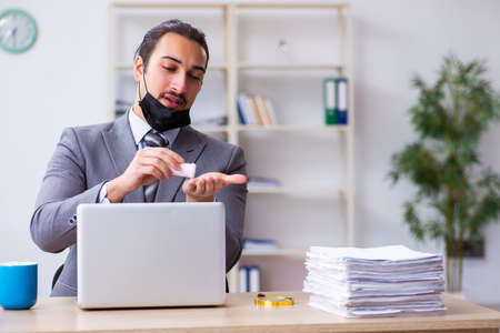 Young male employee in self-quarantine conceptの写真素材