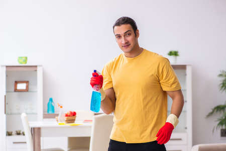 Young male contractor cleaning the house