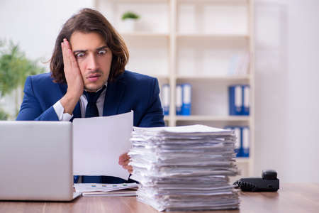 Young male employee unhappy with excessive work