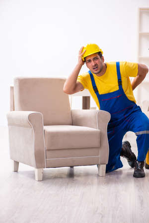 Young male contractor in relocation conceptの写真素材