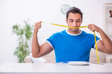 Young hungry man in dieting conceptの写真素材