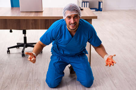 Young male doctor surgeon in fatal negligence conceptの写真素材