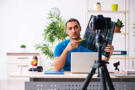 Young male doctor recording video for his blog