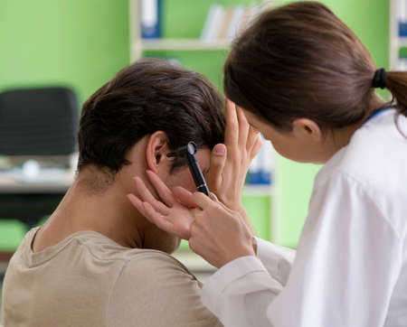 Female doctor checking patients ear during medical examinationの写真素材