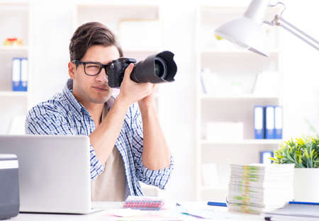 Young photographer working with his cameraの写真素材