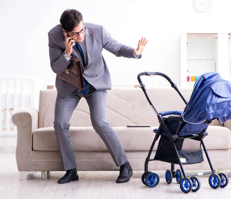 Businessman looking after newborn baby at home and teleworking